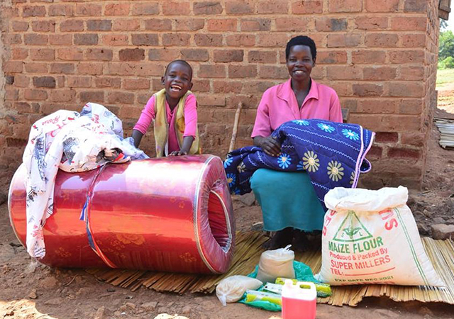 Yofisa and his mother celebrate the gifts in kind received with the help of donors and ChildFund resources.