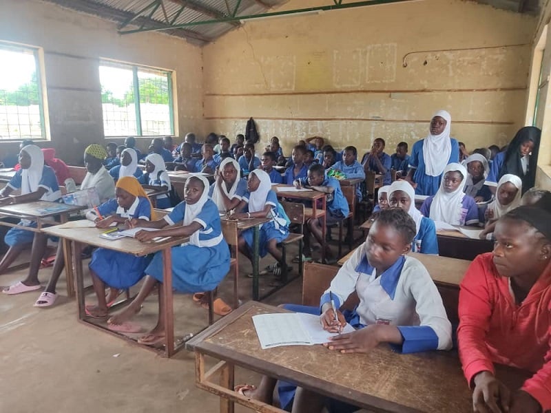 Children in The Gambia sit in a classroom, learning.