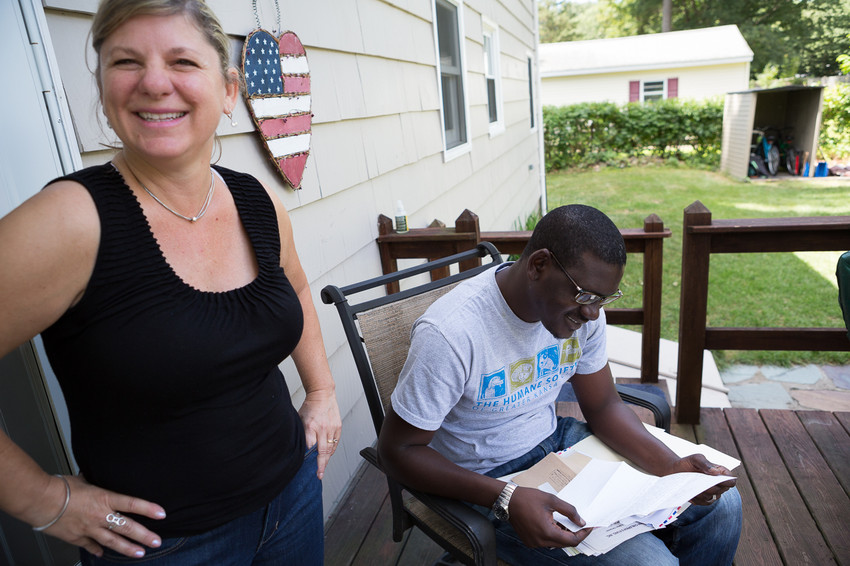 Momodou M. Bah of the Gambia looks through the old letters he sent to Debbie Gautreau while she was sponsoring him as a child through the ChildFund at her house in Northborough, MA on August 8, 2015.