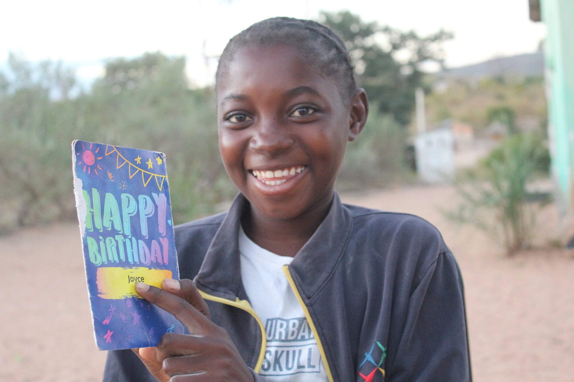 All smiles as a child receives a birthday card from her sponsor.